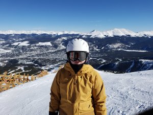 Dr. Yihan in ski gear on a mountain